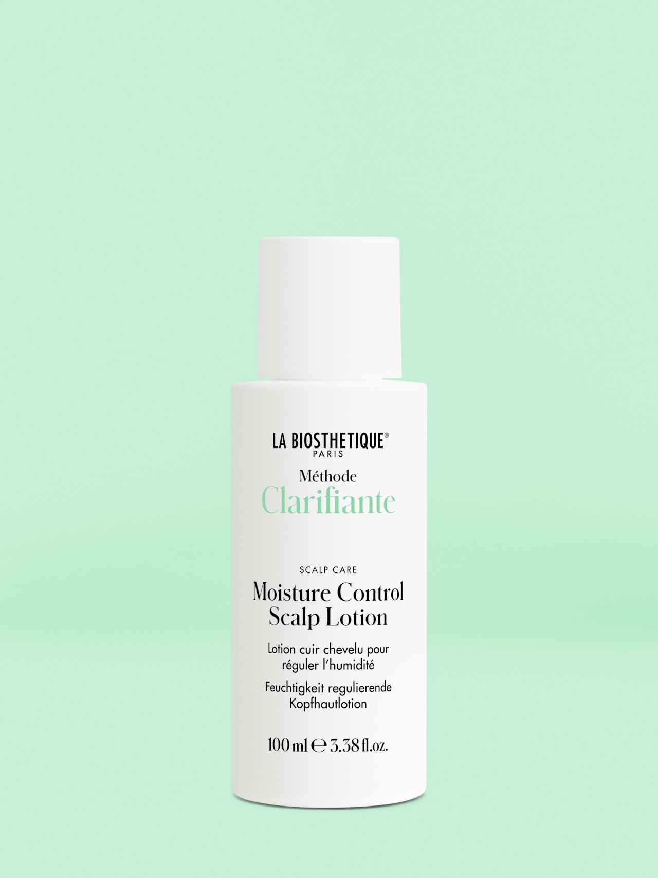 White bottle with screw cap of Moisture Control Scalp Lotion on a light green background.